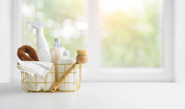 About: Cleaning products in a basket on a table in front of a window.