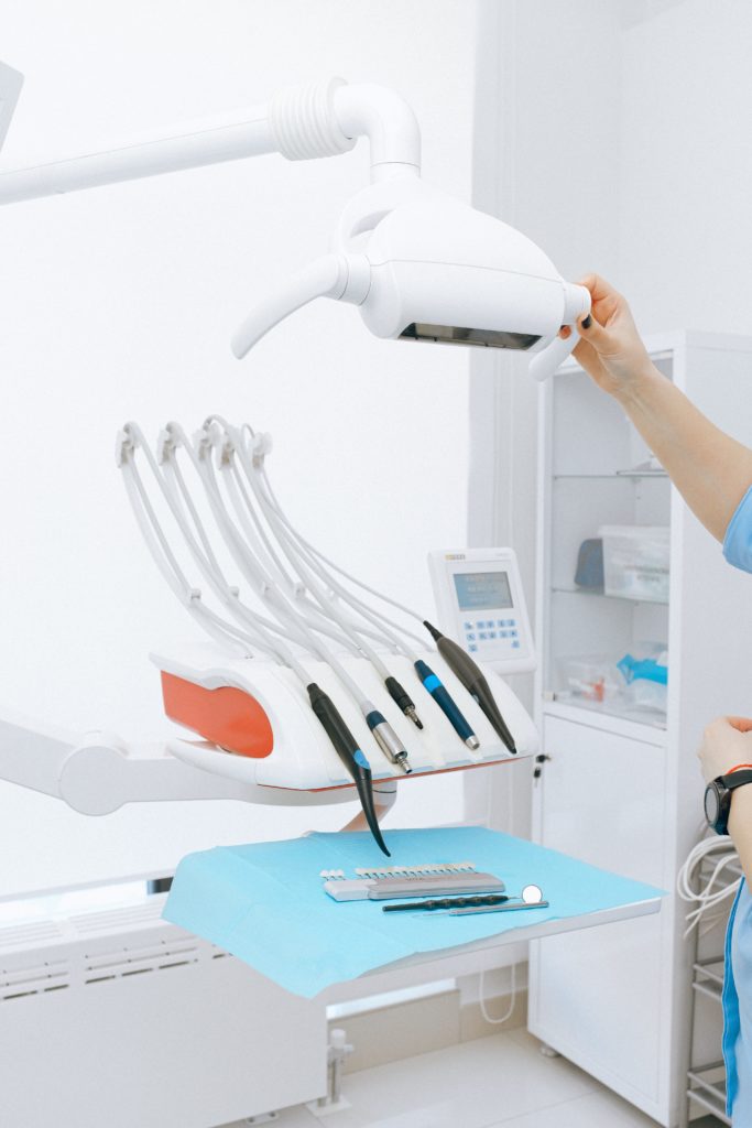 A dentist is working on a dental machine in a healthcare facility.