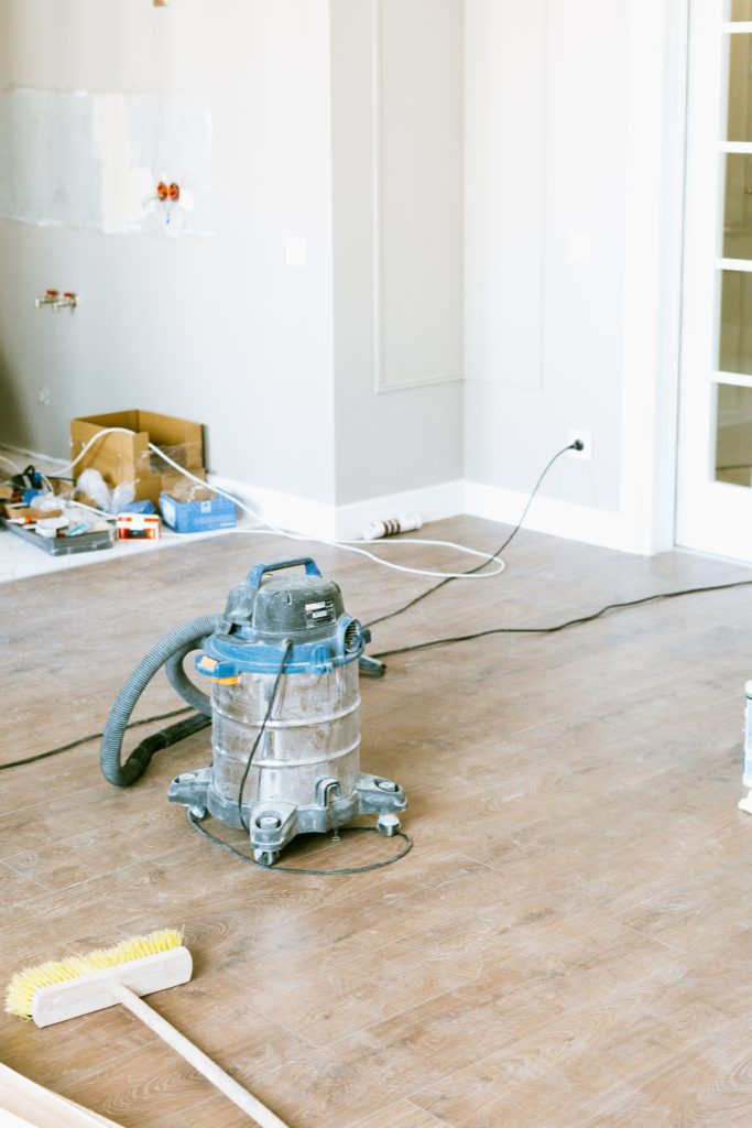 A room in Surrey is undergoing post renovation cleaning using a vacuum cleaner.